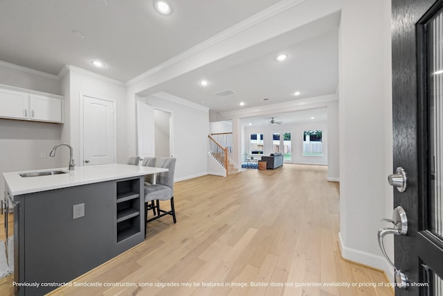 833 Fisher St Unit C, Houston, TX 77018 - kitchen featuring a sink, an island with sink, light wood finished floors, crown molding, and white cabinets