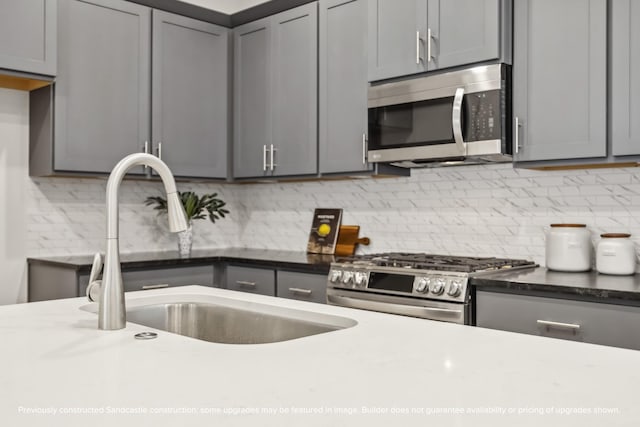 833 Fisher St Unit C, Houston, TX 77018 - kitchen featuring appliances with stainless steel finishes, gray cabinetry, a sink, and decorative backsplash