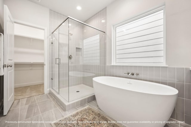 833 Fisher St Unit C, Houston, TX 77018 - bathroom featuring a freestanding bath, a stall shower, a walk in closet, tile walls, and tile patterned flooring