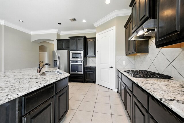 4914 Fairford Dr, Sugar Land, TX 77479 - kitchen featuring stainless steel appliances, under cabinet range hood, arched walkways, ornamental molding, and light stone countertops
