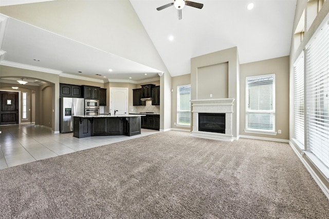 4914 Fairford Dr, Sugar Land, TX 77479 - unfurnished living room featuring ceiling fan, light colored carpet, arched walkways, crown molding, and healthy amount of natural light
