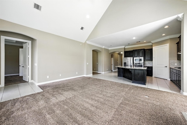 4914 Fairford Dr, Sugar Land, TX 77479 - unfurnished living room with arched walkways, light tile patterned floors, light colored carpet, recessed lighting, and ornamental molding