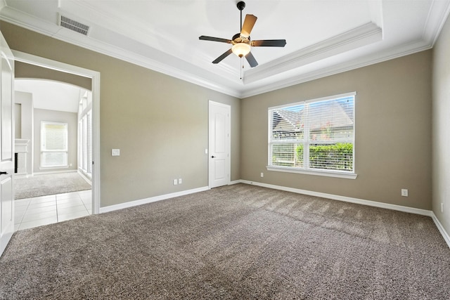 4914 Fairford Dr, Sugar Land, TX 77479 - tiled empty room featuring carpet floors, crown molding, a tray ceiling, ceiling fan, and arched walkways