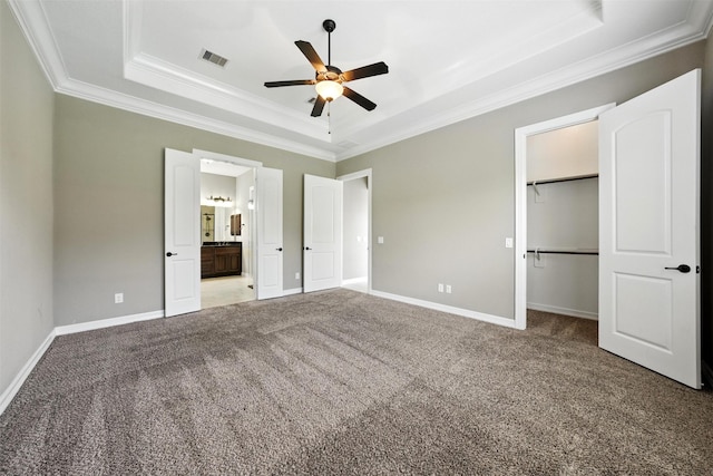 4914 Fairford Dr, Sugar Land, TX 77479 - unfurnished bedroom featuring a tray ceiling, ornamental molding, carpet flooring, a spacious closet, and connected bathroom