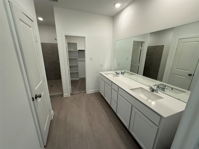 317 Tejas Trl, Waller, TX 77484 - bathroom with wood finished floors, double vanity, tiled shower, recessed lighting, and a closet