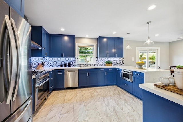 2050 Marnel Rd, Houston, TX 77055 - kitchen featuring appliances with stainless steel finishes, blue cabinets, a peninsula, healthy amount of natural light, and recessed lighting