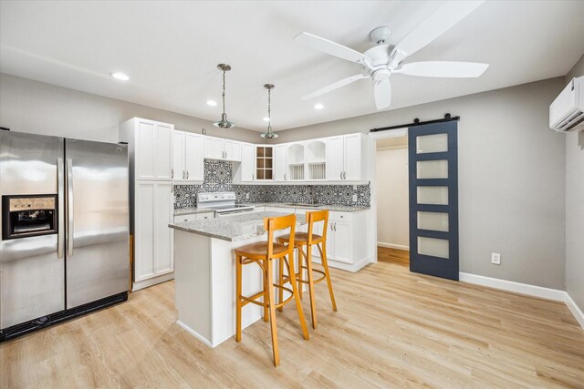 2050 Marnel Rd, Houston, TX 77055 - kitchen featuring stainless steel fridge with ice dispenser, a barn door, white range with electric stovetop, a breakfast bar, and white cabinetry