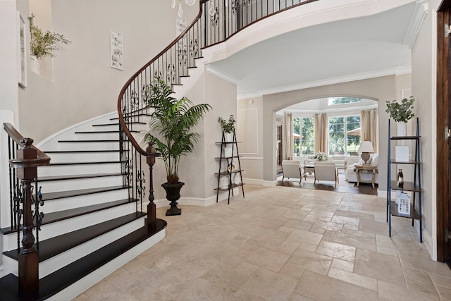 26 Commanders Pt, Missouri City, TX 77459 - foyer with stone tile floors, arched walkways, a high ceiling, baseboards, and ornamental molding