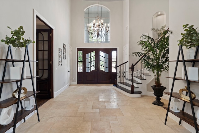 26 Commanders Pt, Missouri City, TX 77459 - entryway with baseboards, stone tile floors, a chandelier, a towering ceiling, and stairway