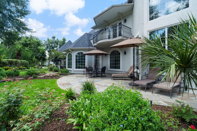 26 Commanders Pt, Missouri City, TX 77459 - rear view of property featuring a balcony, a patio, stucco siding, and a shingled roof