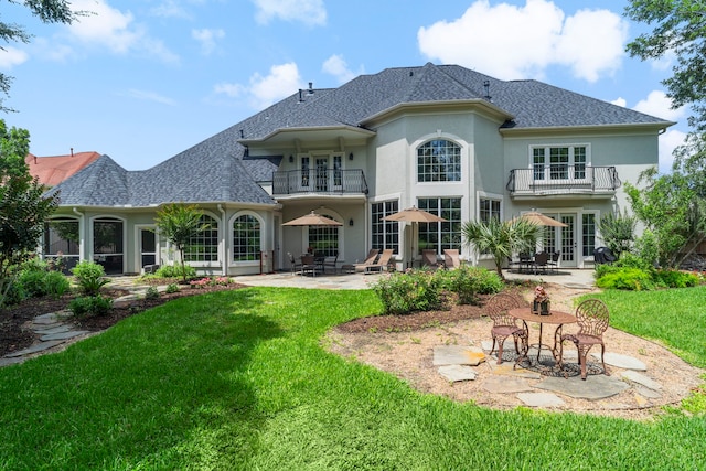 26 Commanders Pt, Missouri City, TX 77459 - rear view of property with a balcony, a patio area, a yard, stucco siding, and a shingled roof