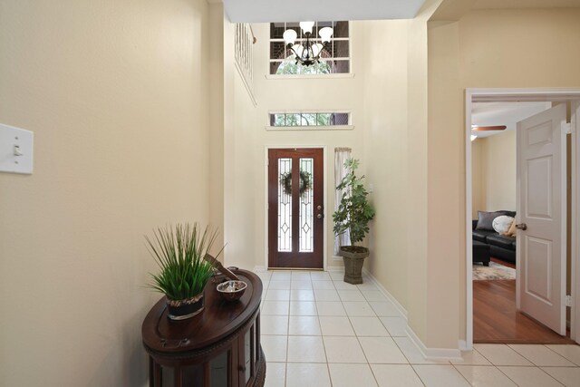 1123 Mariner Cv, Sugar Land, TX 77498 - foyer entrance featuring light tile patterned flooring, a chandelier, baseboards, and a high ceiling