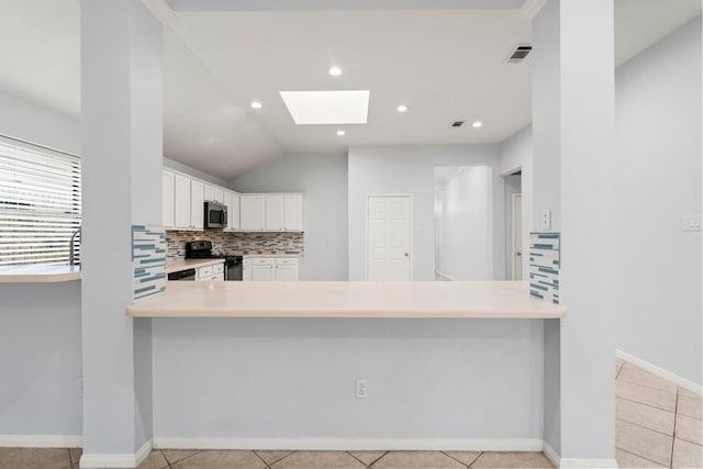1030 Evandale Ln, Sugar Land, TX 77479 - kitchen with stainless steel microwave, black gas stove, a skylight, a peninsula, and decorative backsplash