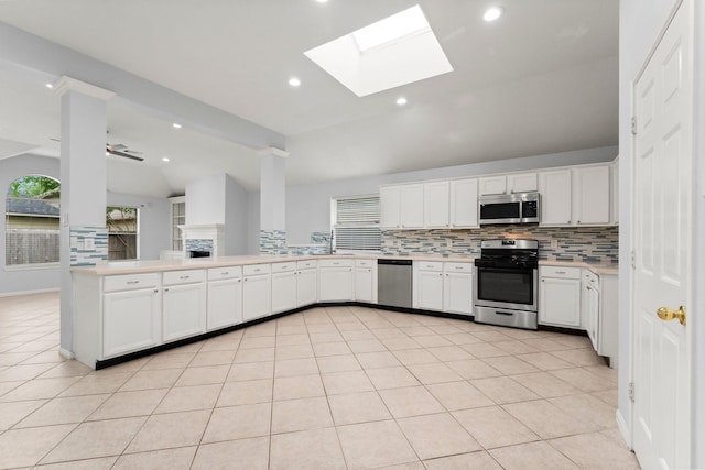 1030 Evandale Ln, Sugar Land, TX 77479 - kitchen featuring stainless steel appliances, backsplash, a skylight, lofted ceiling, and light countertops