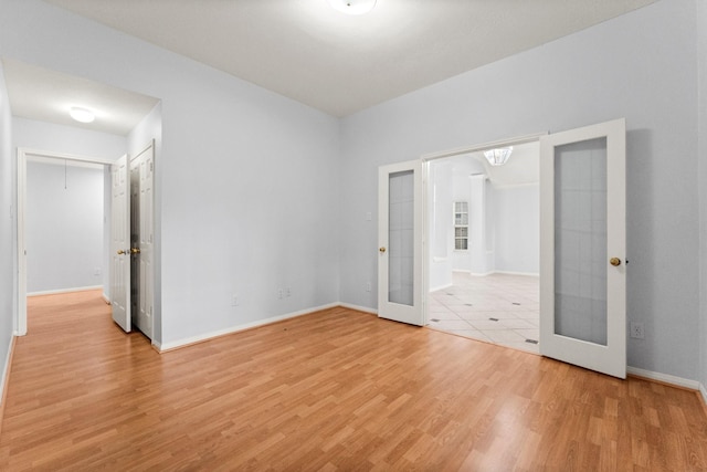 1030 Evandale Ln, Sugar Land, TX 77479 - unfurnished bedroom featuring french doors, light wood-type flooring, and baseboards