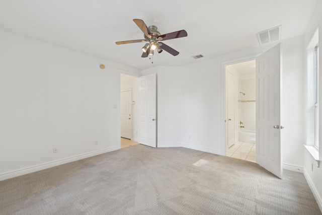 5731 Kansas St, Houston, TX 77007 - unfurnished bedroom featuring light carpet, baseboards, ensuite bath, and ceiling fan