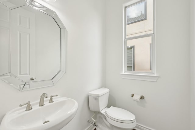 5731 Kansas St, Houston, TX 77007 - half bathroom featuring a sink, toilet, and baseboards