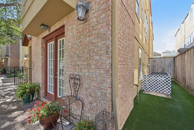 5731 Kansas St, Houston, TX 77007 - view of side of home with brick siding, french doors, and a fenced backyard