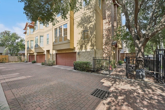 5731 Kansas St, Houston, TX 77007 - view of front of property featuring stone siding, stucco siding, a garage, and driveway