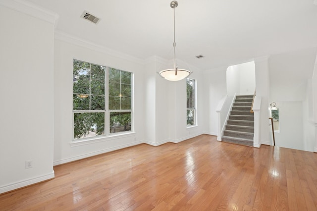 5731 Kansas St, Houston, TX 77007 - unfurnished living room featuring stairs, light wood-type flooring, baseboards, and crown molding