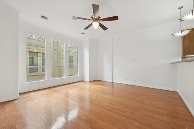5731 Kansas St, Houston, TX 77007 - spare room featuring a ceiling fan, light wood-style flooring, crown molding, and baseboards