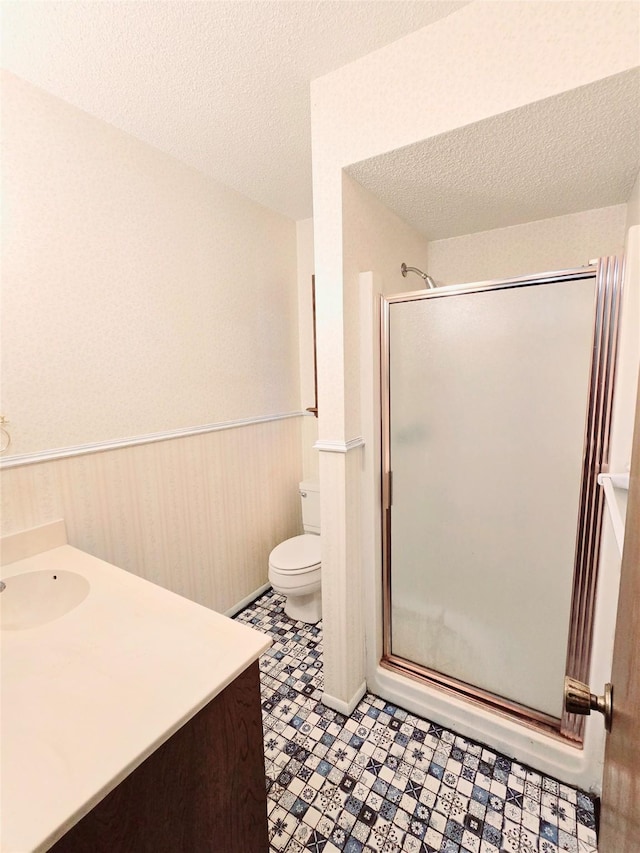 5000 Magnolia Ln, Bay City, TX 77414 - full bathroom featuring a stall shower, vanity, toilet, a wainscoted wall, and a textured ceiling