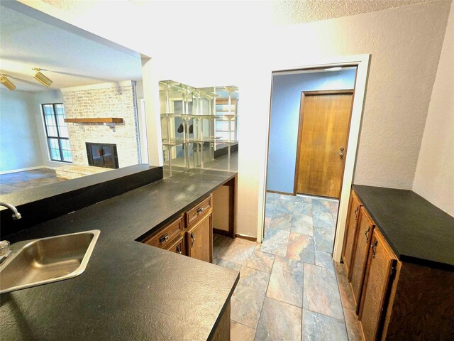 5000 Magnolia Ln, Bay City, TX 77414 - kitchen featuring stone tile flooring, a sink, dark countertops, and brown cabinets