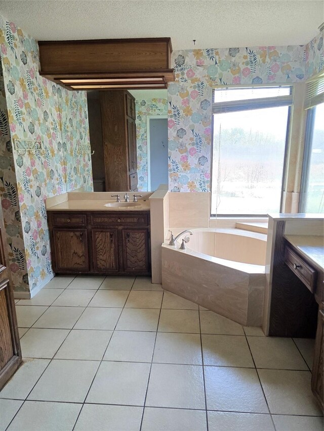 5000 Magnolia Ln, Bay City, TX 77414 - full bathroom featuring wallpapered walls, vanity, a garden tub, a textured ceiling, and tile patterned floors