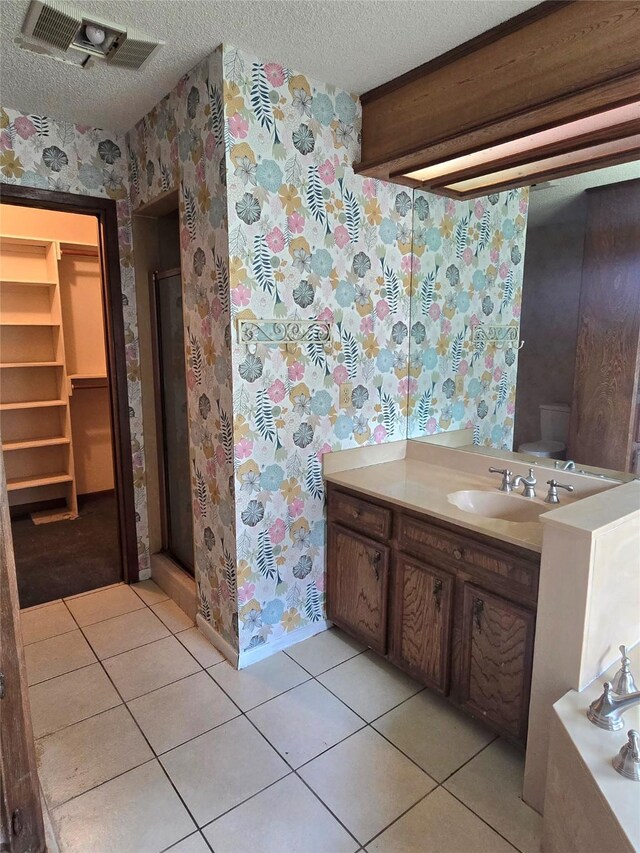 5000 Magnolia Ln, Bay City, TX 77414 - bathroom with wallpapered walls, a textured ceiling, vanity, tile patterned floors, and a stall shower