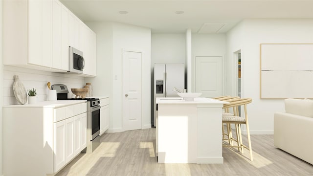 321 Tejas Trl, Waller, TX 77484 - kitchen with appliances with stainless steel finishes, a center island, light wood-style floors, and white cabinets