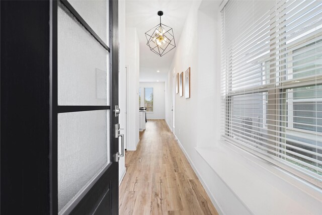 4234 Balboa Dr, Iowa Colony, TX 77583 - hall with light wood finished floors, a chandelier, and baseboards