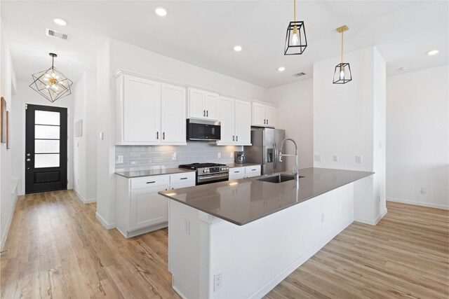 4234 Balboa Dr, Iowa Colony, TX 77583 - kitchen featuring appliances with stainless steel finishes, a sink, light wood finished floors, a peninsula, and recessed lighting