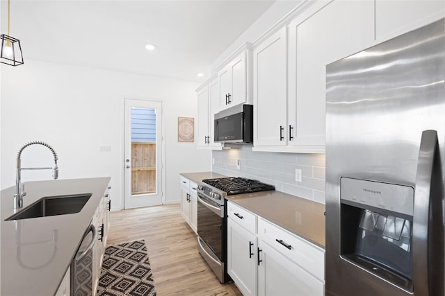 4234 Balboa Dr, Iowa Colony, TX 77583 - kitchen with appliances with stainless steel finishes, a sink, light wood-style floors, decorative backsplash, and recessed lighting