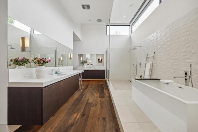 2110 Tangley St, Houston, TX 77005 - full bath featuring a towering ceiling, a walk in shower, a freestanding bath, vanity, and wood-type flooring