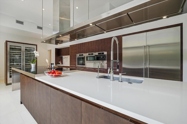 2110 Tangley St, Houston, TX 77005 - kitchen featuring modern cabinets, black electric cooktop, light tile patterned floors, built in fridge, and light countertops