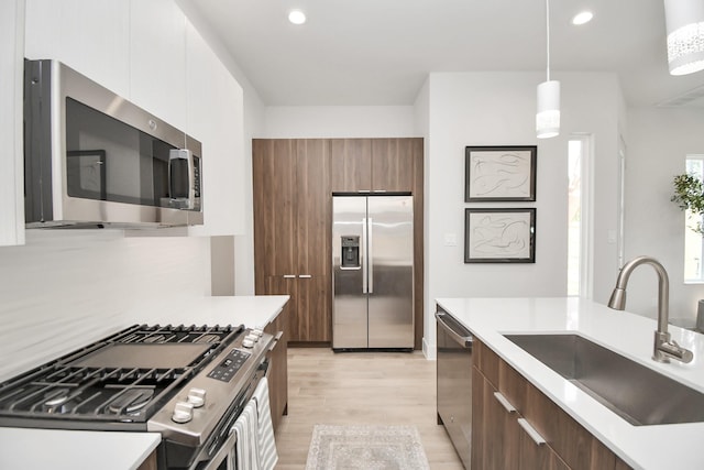 4011 Boho Ln, Houston, TX 77045 - kitchen with stainless steel appliances, a sink, modern cabinets, light wood-type flooring, and recessed lighting