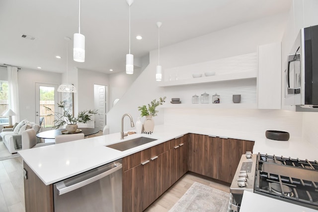 4011 Boho Ln, Houston, TX 77045 - kitchen featuring stainless steel appliances, a sink, modern cabinets, a peninsula, and light countertops