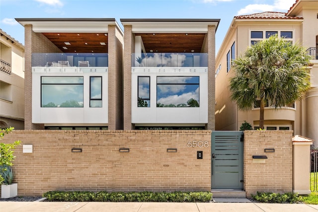 6508 Haskell St, Houston, TX 77007 - view of front of home with stucco siding, a fenced front yard, and a gate