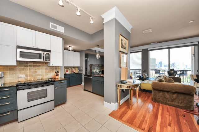 3333 Allen Pkwy Unit 1508, Houston, TX 77019 - kitchen with appliances with stainless steel finishes, white cabinets, open floor plan, dark countertops, and backsplash