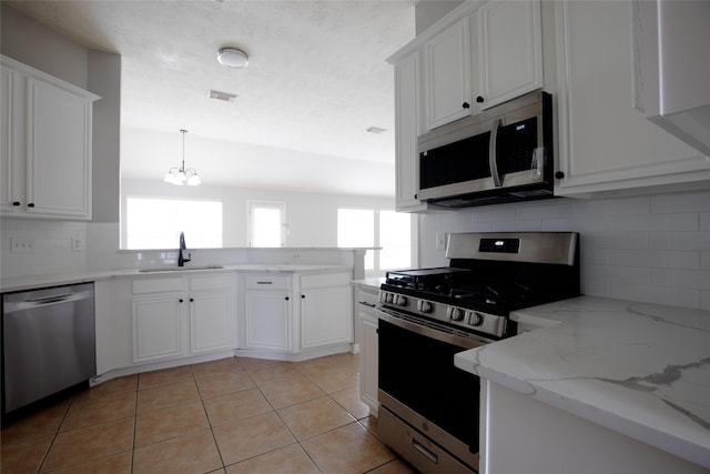 19915 Mason Creek Dr, Katy, TX 77449 - kitchen featuring stainless steel appliances, a sink, healthy amount of natural light, and a peninsula