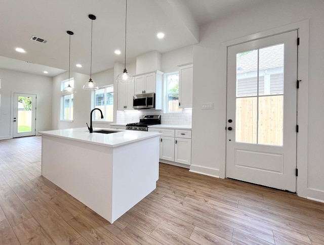 3109 Orange St, Houston, TX 77020 - kitchen with appliances with stainless steel finishes, light wood-style floors, decorative backsplash, white cabinets, and recessed lighting