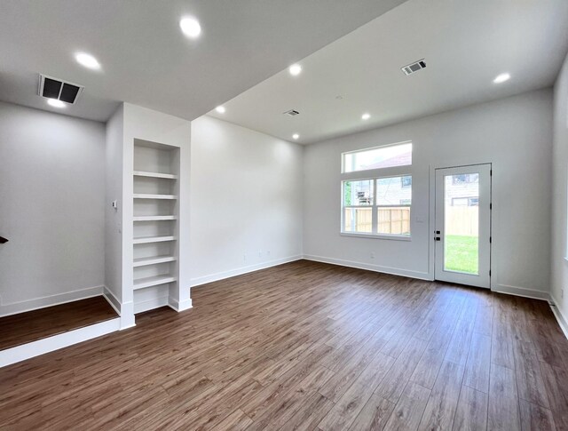 3109 Orange St, Houston, TX 77020 - spare room with built in shelves, dark wood-style flooring, baseboards, and recessed lighting