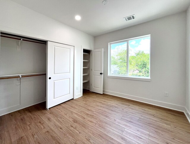 3109 Orange St, Houston, TX 77020 - unfurnished bedroom with light wood finished floors, baseboards, a closet, and recessed lighting