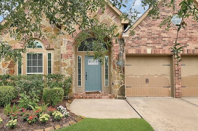 4003 N Creekmont Dr, Fresno, TX 77545 - entrance to property featuring concrete driveway, stone siding, a garage, and brick siding