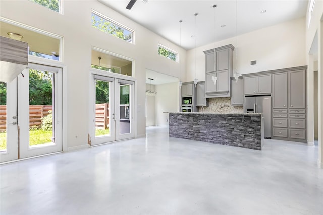 538 Magnolia Point Dr, Huffman, TX 77336 - unfurnished living room with french doors, a towering ceiling, finished concrete floors, and a ceiling fan