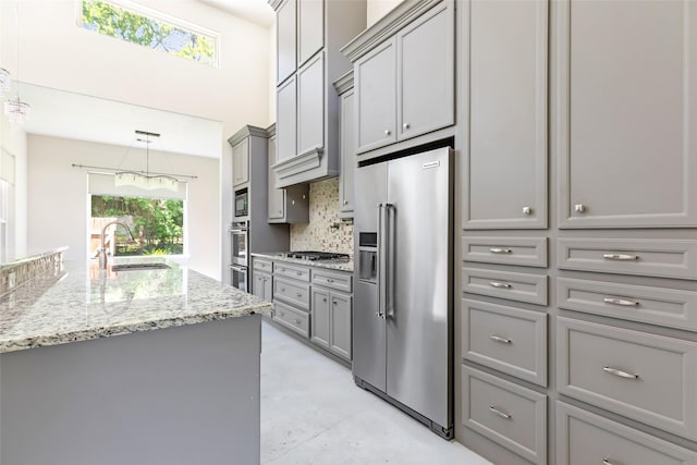 538 Magnolia Point Dr, Huffman, TX 77336 - kitchen featuring gray cabinetry, stainless steel appliances, a sink, finished concrete flooring, and backsplash