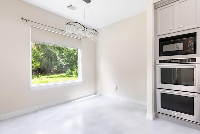 538 Magnolia Point Dr, Huffman, TX 77336 - kitchen with black microwave, double oven, concrete floors, baseboards, and decorative light fixtures
