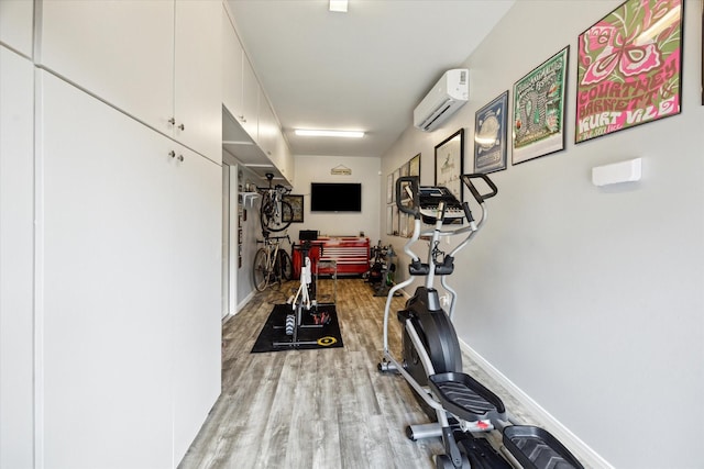 446 Arlington St, Houston, TX 77007 - workout area with a wall mounted AC, light wood-style flooring, and baseboards