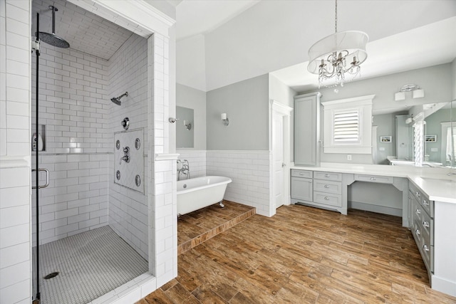 446 Arlington St, Houston, TX 77007 - bathroom with a stall shower, vanity, a freestanding tub, wood finished floors, and tile walls