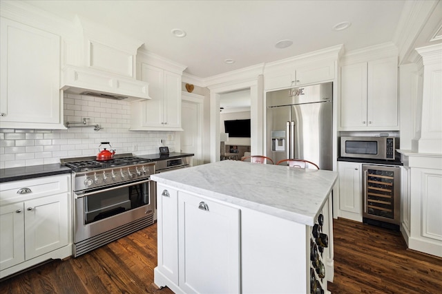 446 Arlington St, Houston, TX 77007 - kitchen with appliances with stainless steel finishes, beverage cooler, dark wood finished floors, a center island, and white cabinetry